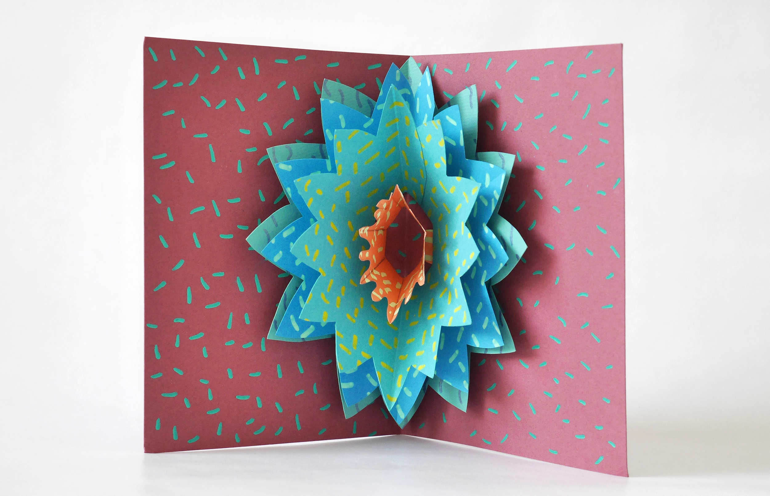 Aus dem Falz von aufgeklappten Papierbogen erhebt Schichten von Papier in Form einer Blume.